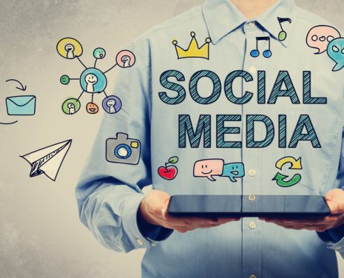 A man holding a tablet, above it are different social media concepts