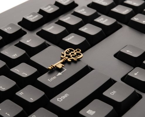 Goldener Schlüssel liegt auf einem schwarzen Keyboard